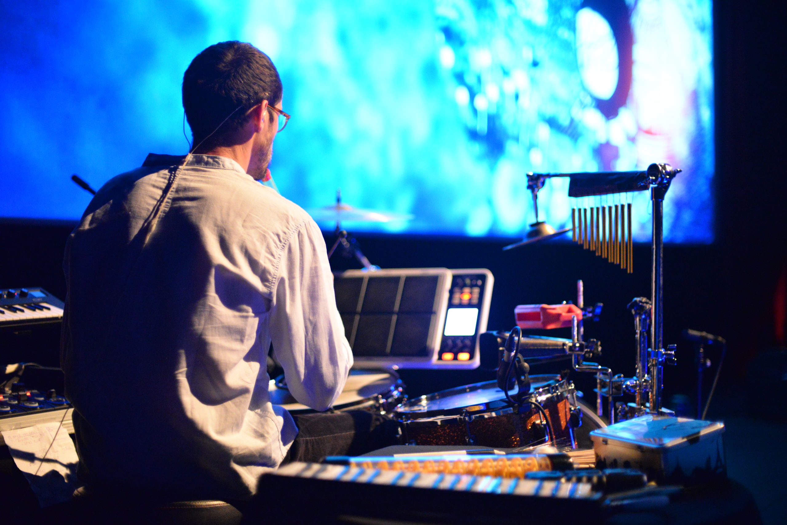 Photo extraite du ciné-concert, avec le musicien en premier plan, et l'écran de cinéma en arrière plan